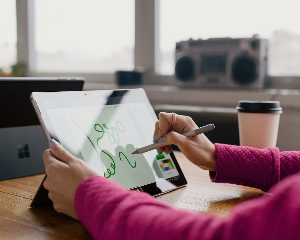 Logoentwicklung auf einem Tablem von einer Frau mit einem Stift in der Hand